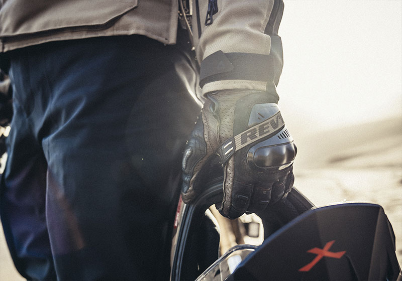 motociclista com capacete na mão