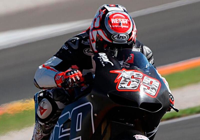 competidor de moto gp em uma corrida utilizando capacete arai